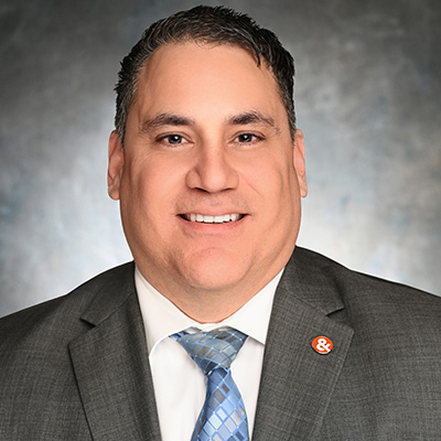John Smith, Durham-Chapel Hill Blvd. Branch Manager at M&F Bank, smiling in a professional suit, emphasizing banking services and customer support.
