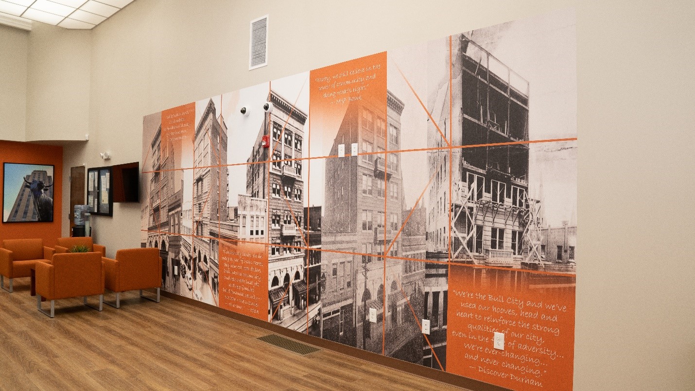 Historical mural featuring black-and-white photographs of buildings and construction, with orange text highlighting community engagement and M&F Bank's commitment to local history.