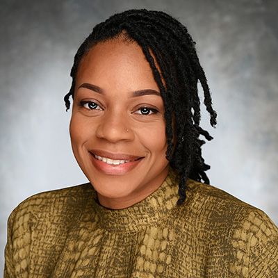 Tiffany Foggie, Marketing Manager at M&F Bank, smiling in a professional portrait with a textured green blouse against a neutral background.