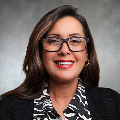 Naz Kamal, Hargett St Branch Manager at M&F Bank, smiling in professional attire, promoting Performance Checking account benefits.